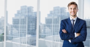 Businessman standing with arms crossed in office